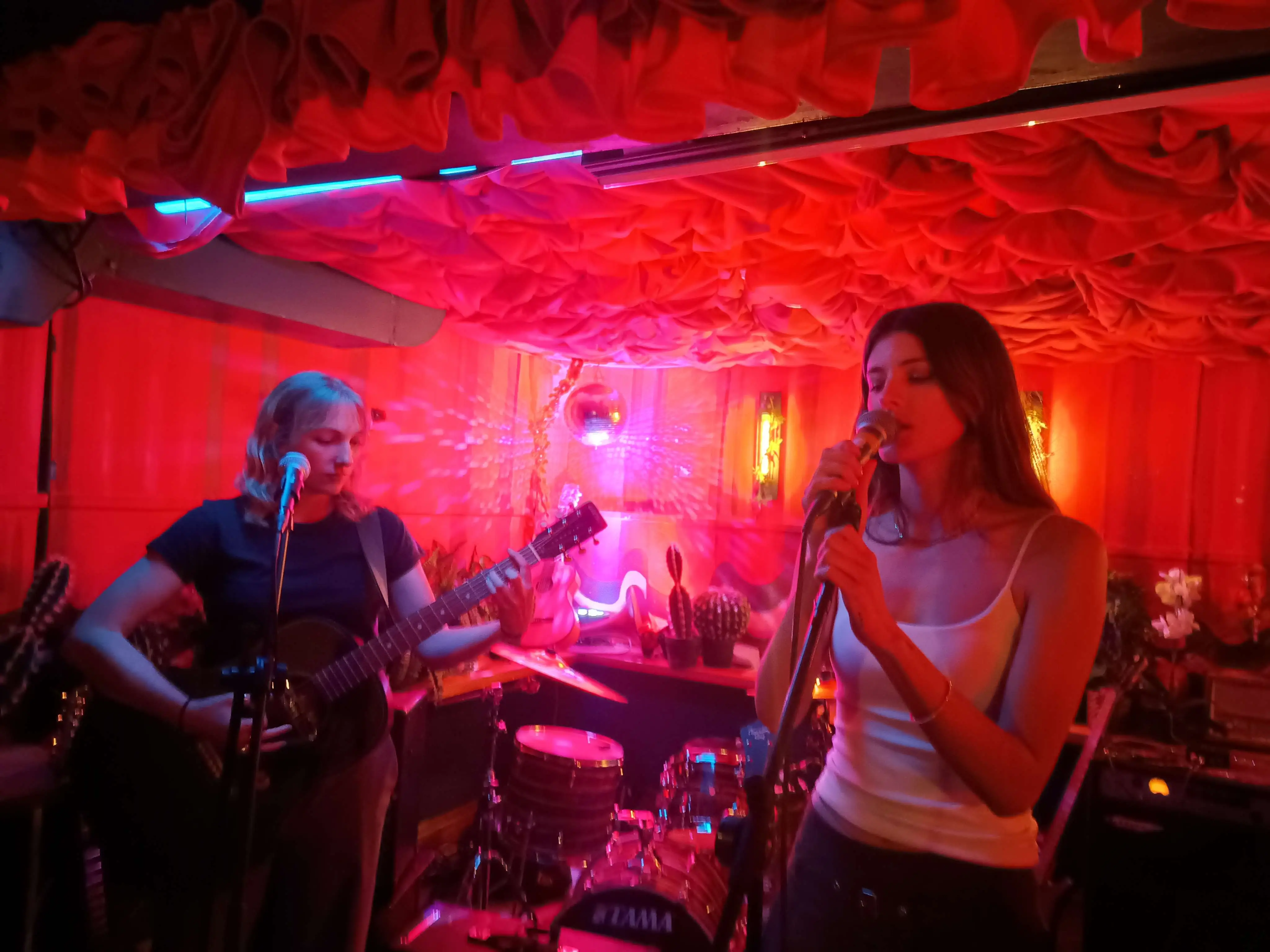 a band performing in a venue that is shrouded in red