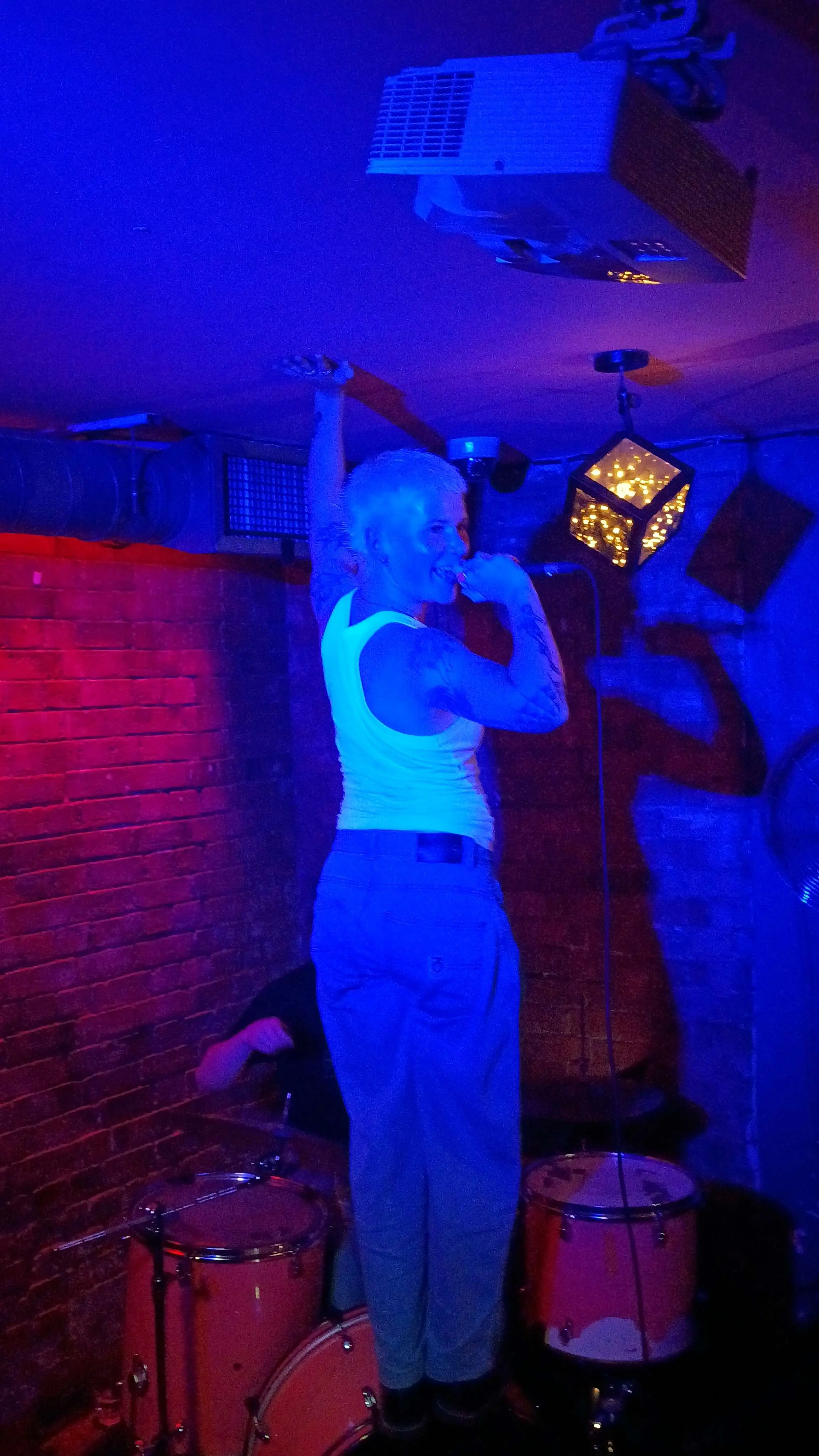 Soft Play standing over the drummer touching the ceiling