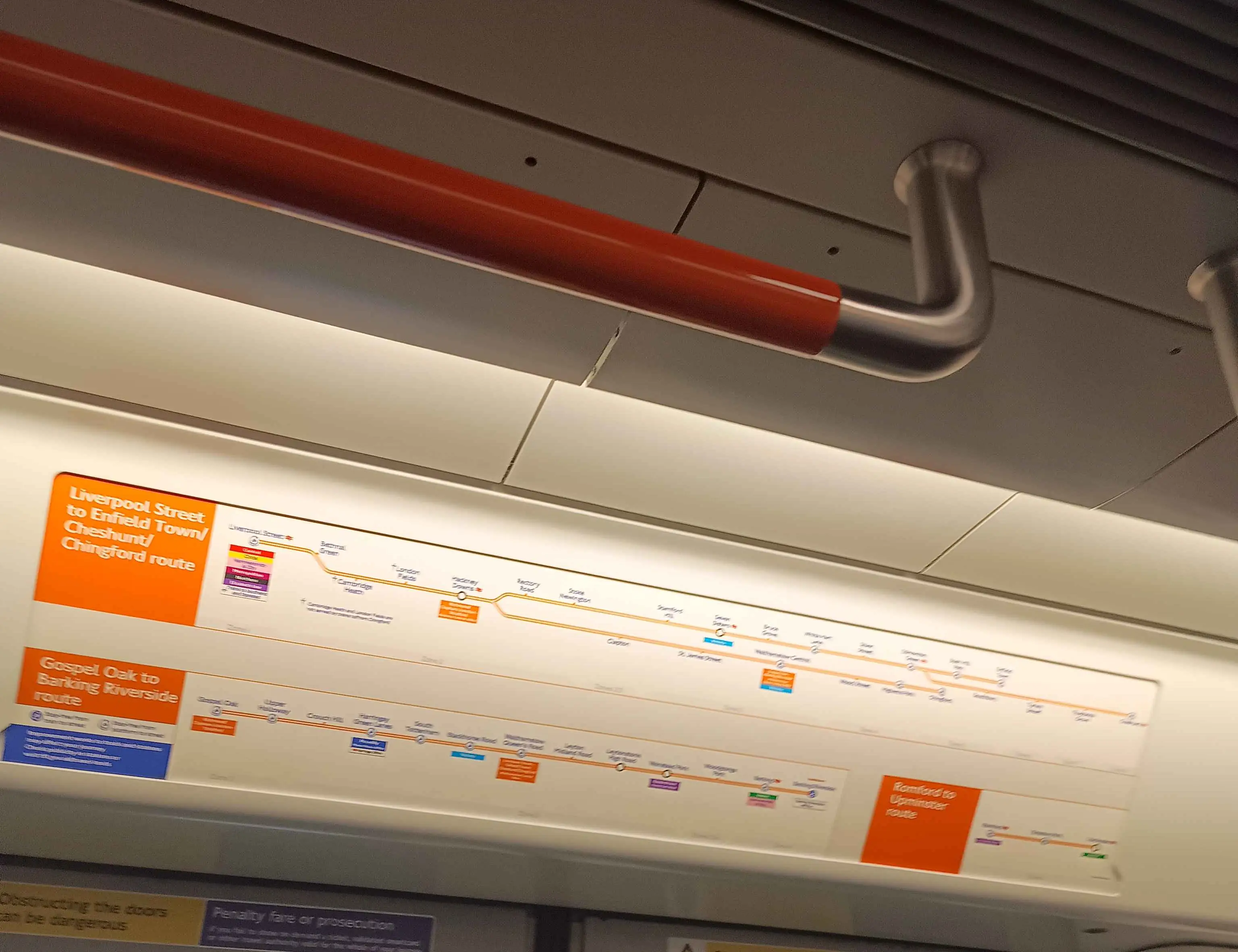 Maps depicting the routes of the Overground, with handles to grab onto in shot.
